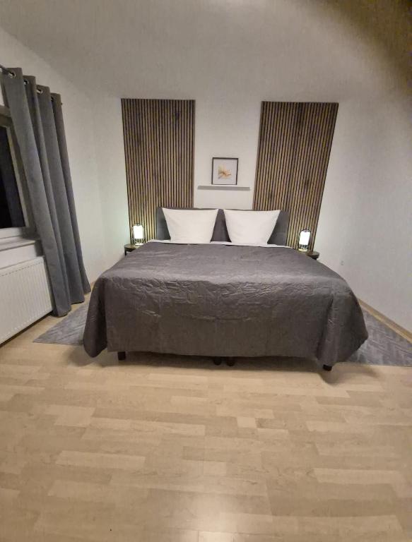 a bedroom with a large bed with two windows at Lem-Lux in Lemgo