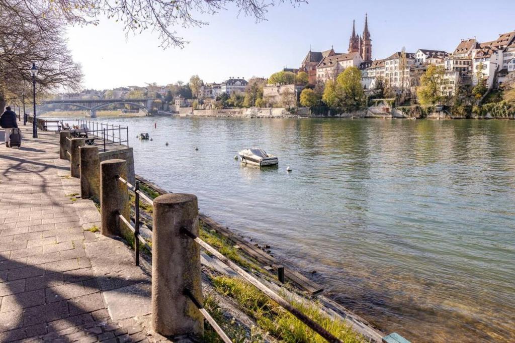 a river with a boat in the water and buildings at Casa Rheinblick - Apartment C in Basel