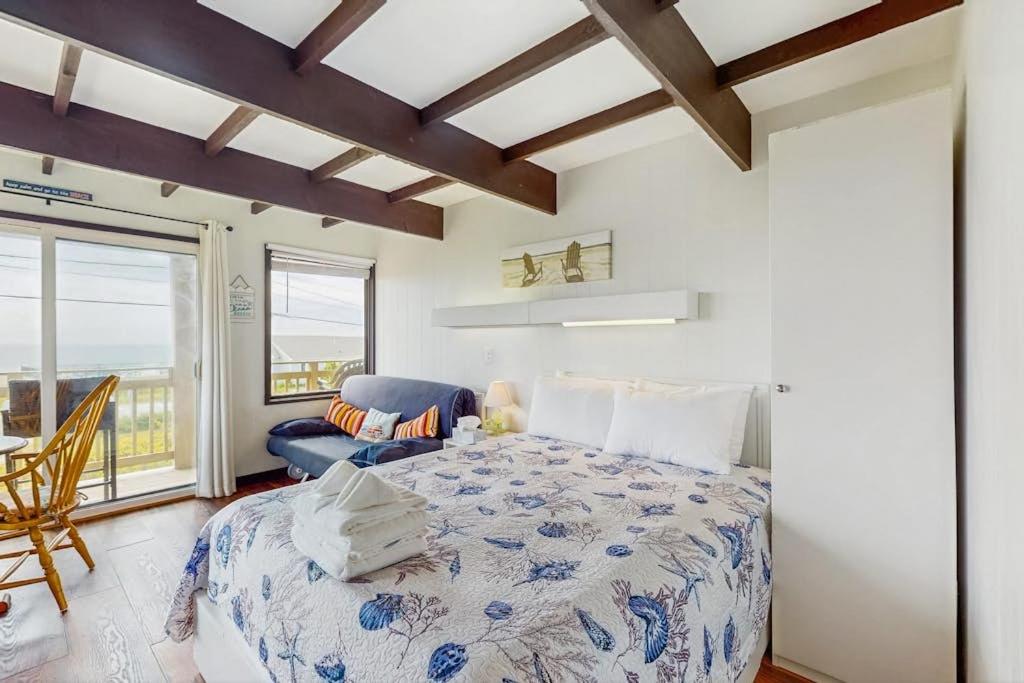 a bedroom with a bed and a chair and a window at Seashore Escape in North Truro
