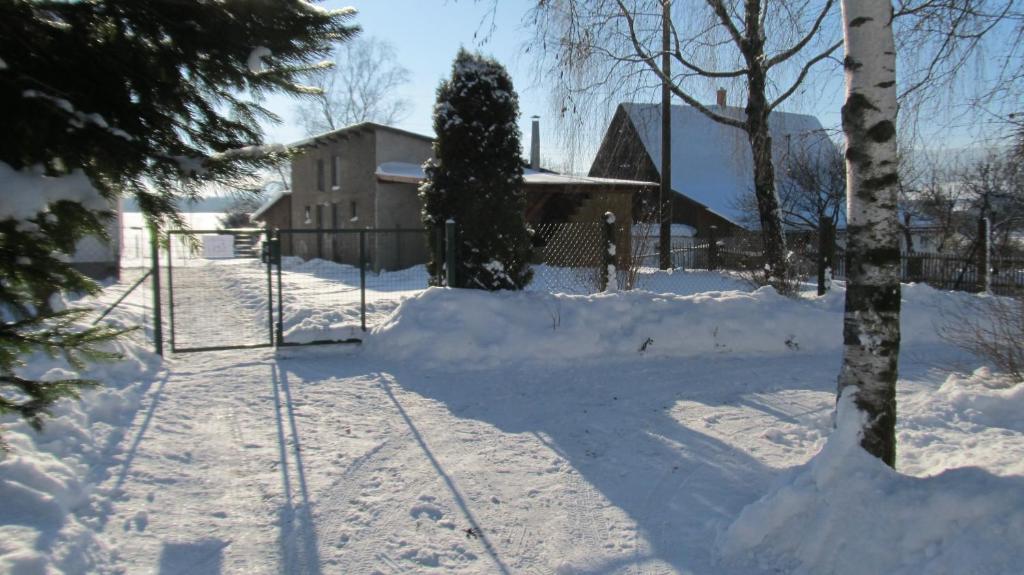 a yard covered in snow with a fence at Apartment Bajt in Králíky