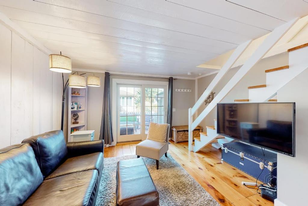 a living room with a couch and a tv at Maushop Village Beach Getaway in Mashpee