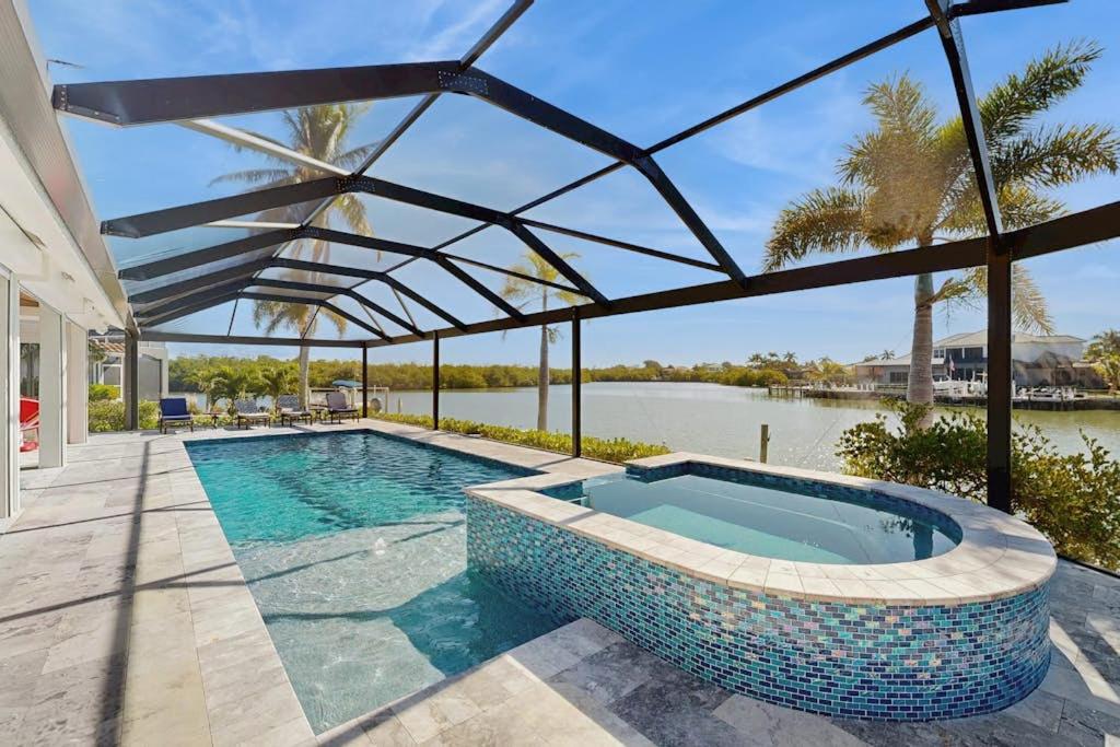 a swimming pool with a view of the water at Dock Holiday in Marco Island