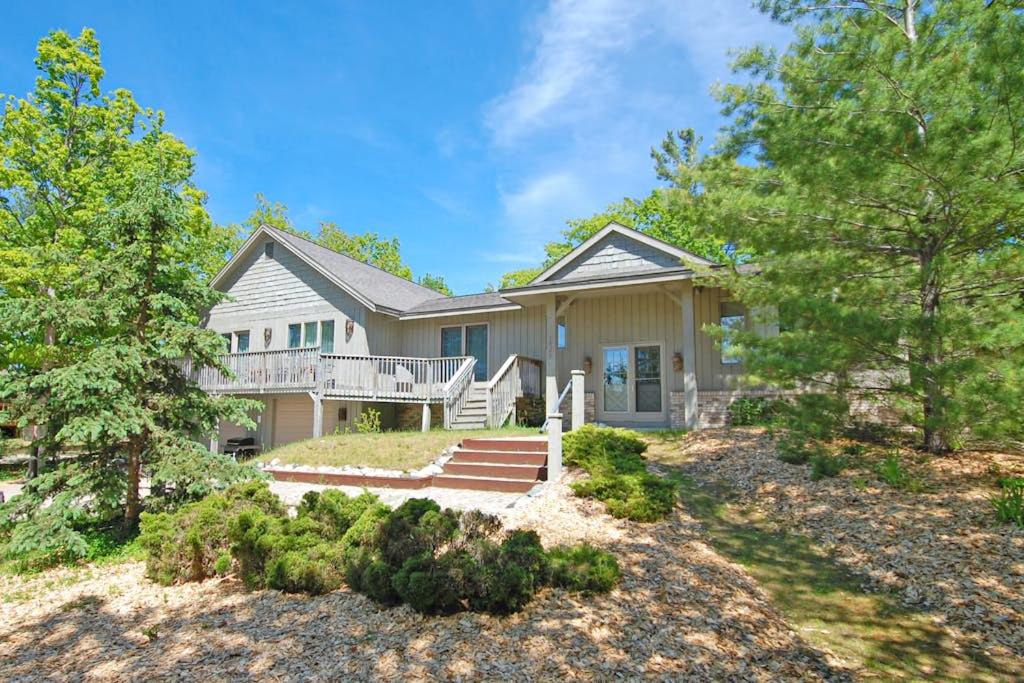 a large house with a porch and a yard at Hal-Sea-On House in Glen Arbor