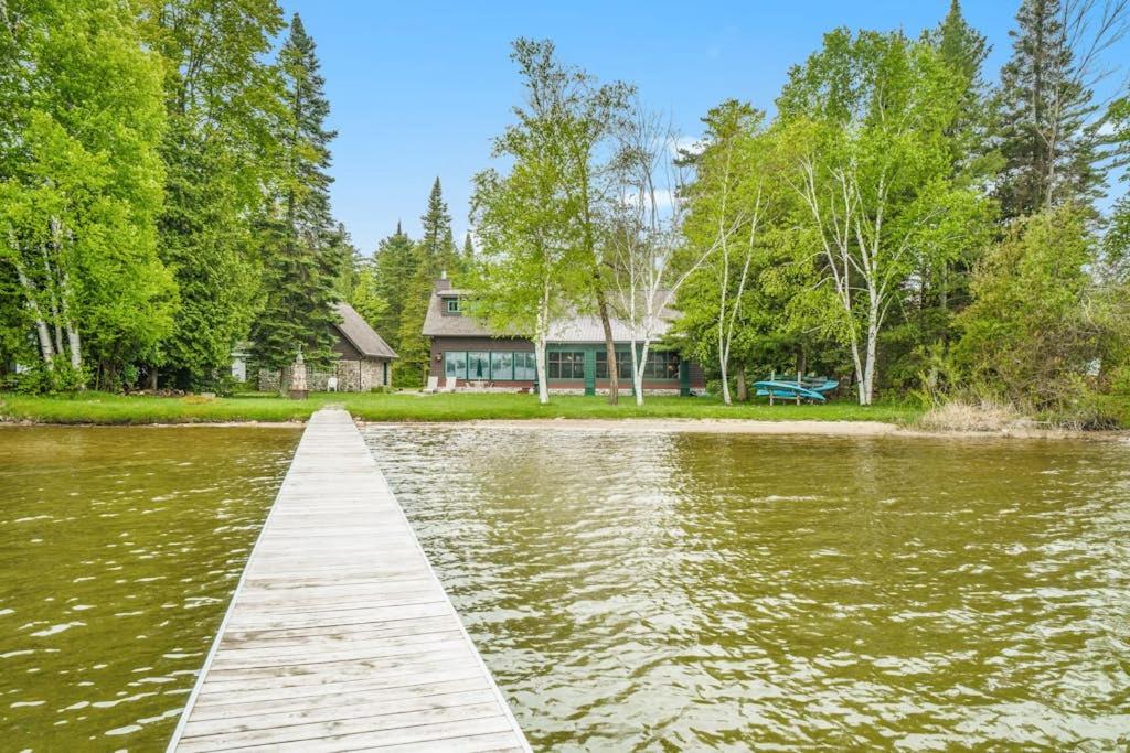 a dock in front of a house on a lake at Platte Lake Paradise in Beulah