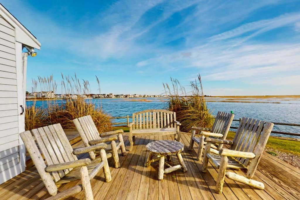 three chairs and a table on a deck overlooking the water at West Dennis Dockside in West Dennis