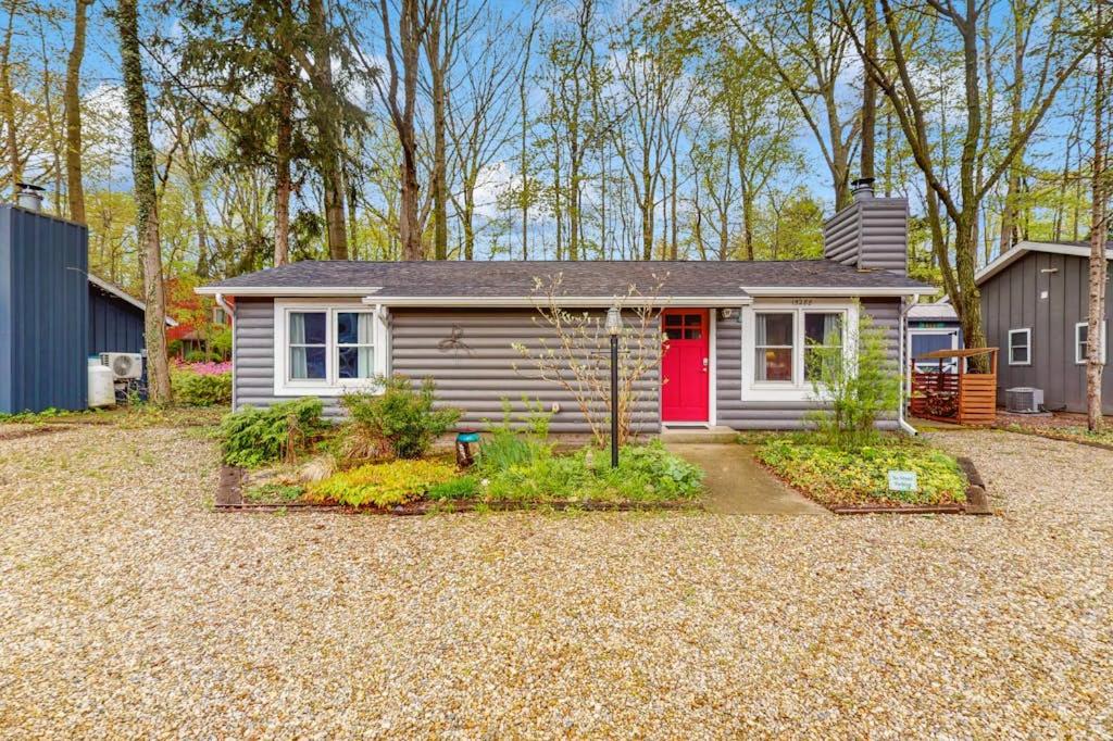 a small house with a red door in a yard at Lake Michigan Adventures in Lakeside