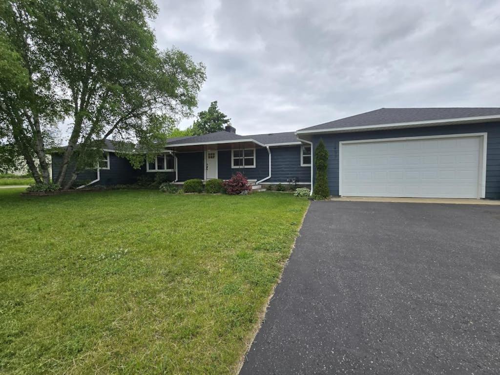 a house with a driveway and a garage at Minutes from it All in Petoskey