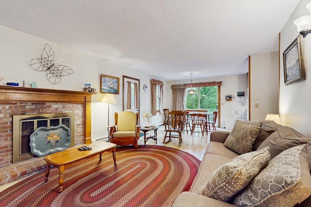 a living room with a couch and a fireplace at Escape in Dennis in Dennis
