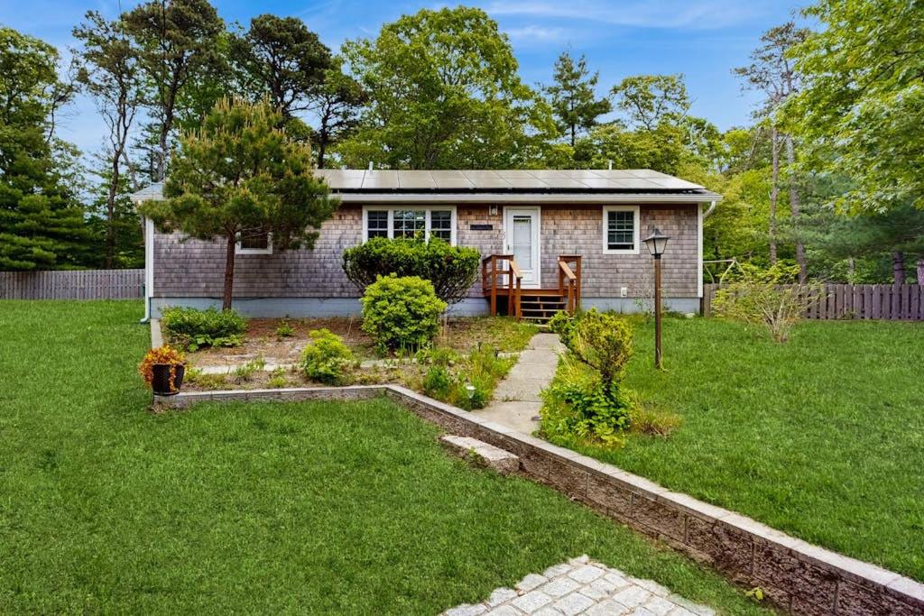 a small house in a yard with a green lawn at The Rootskeller in Oak Bluffs