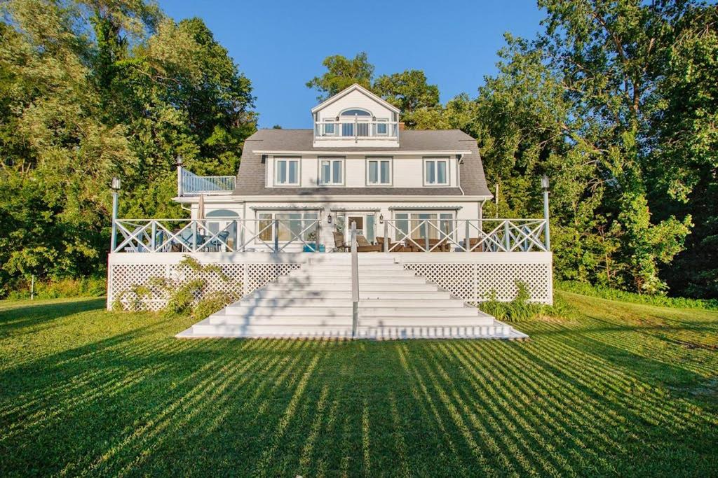 a large white house with stairs in front of it at Lake Michigan Retreat- Upper Duplex in Benton Harbor