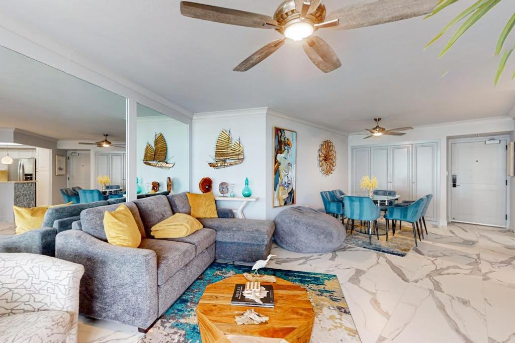 a living room with a couch and a ceiling fan at Waves & Palms Oasis in Marco Island