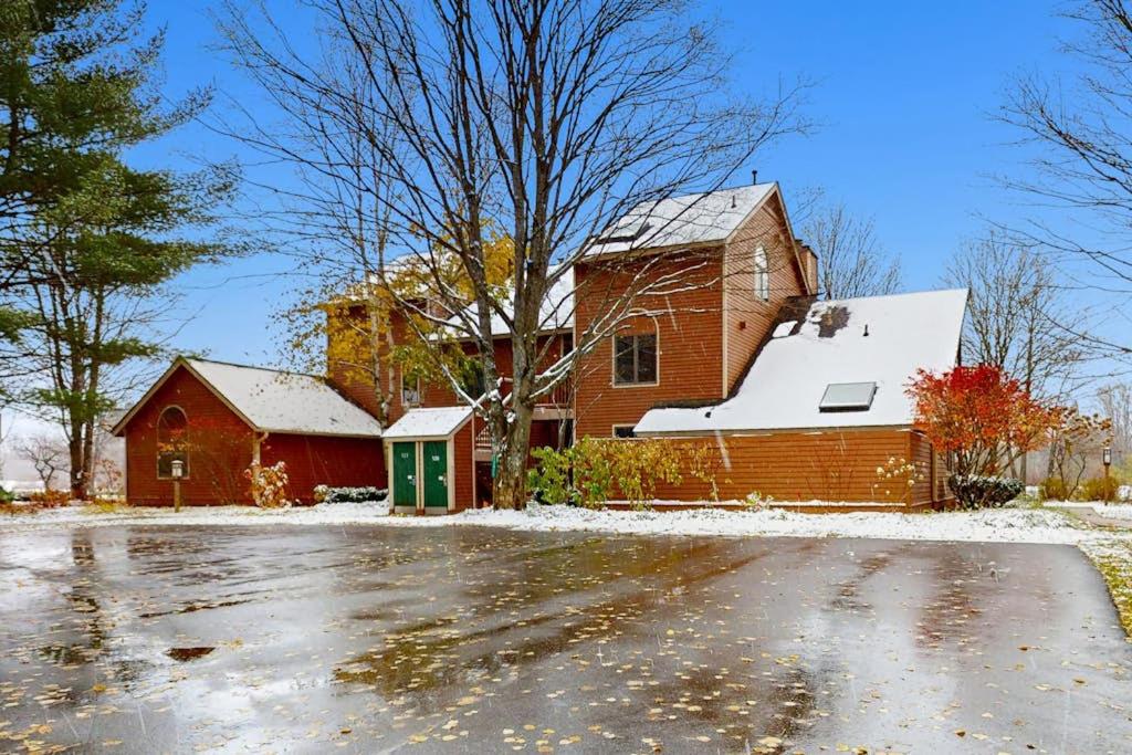 a red brick house with snow on the ground at WinterGreen Condo, #522 in Thompsonville