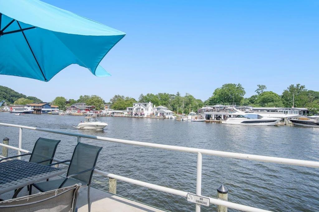a deck with two chairs and an umbrella on a boat at Waterside Suites in Saugatuck