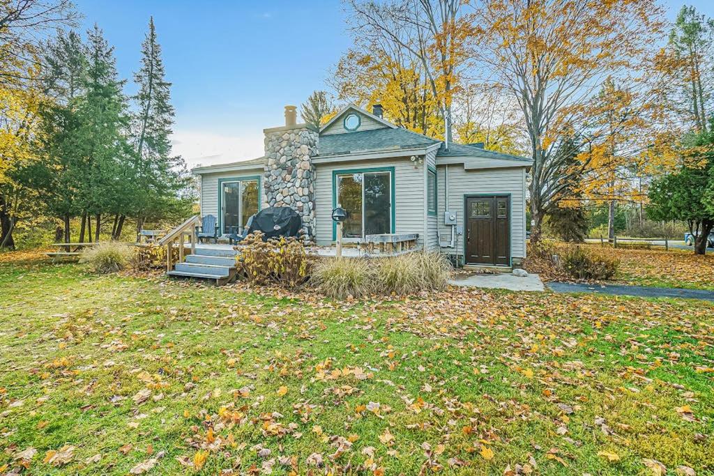 ein kleines blaues Haus mit Veranda und Garten in der Unterkunft Riverside Abode in Thompsonville