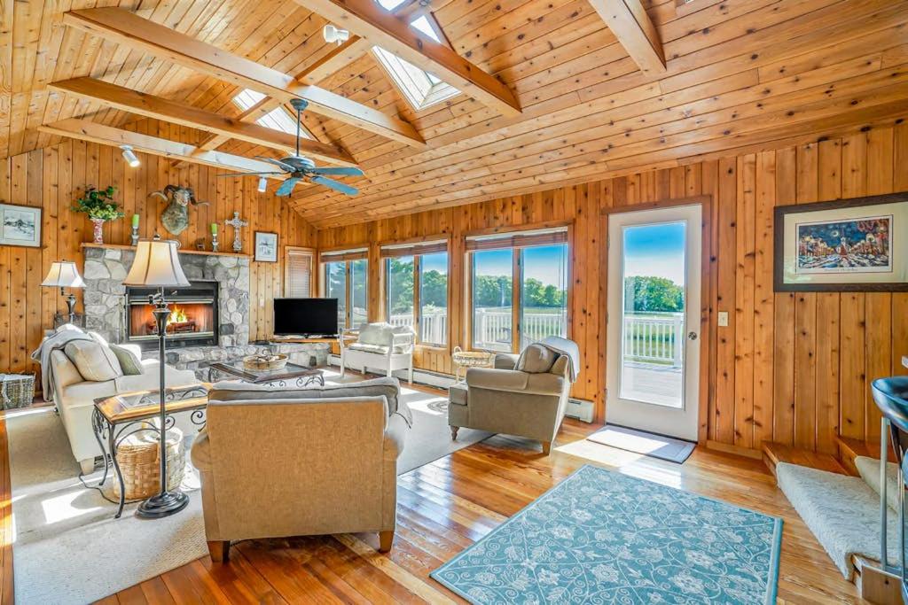 a living room with wooden walls and wooden floors at Birchwood: Meadows Bliss in Harbor Springs