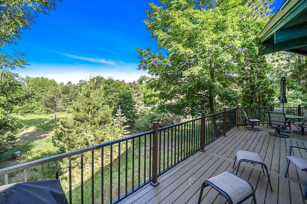 a deck with chairs and tables and a fence at Petoskey Stone Lodge in Bellaire