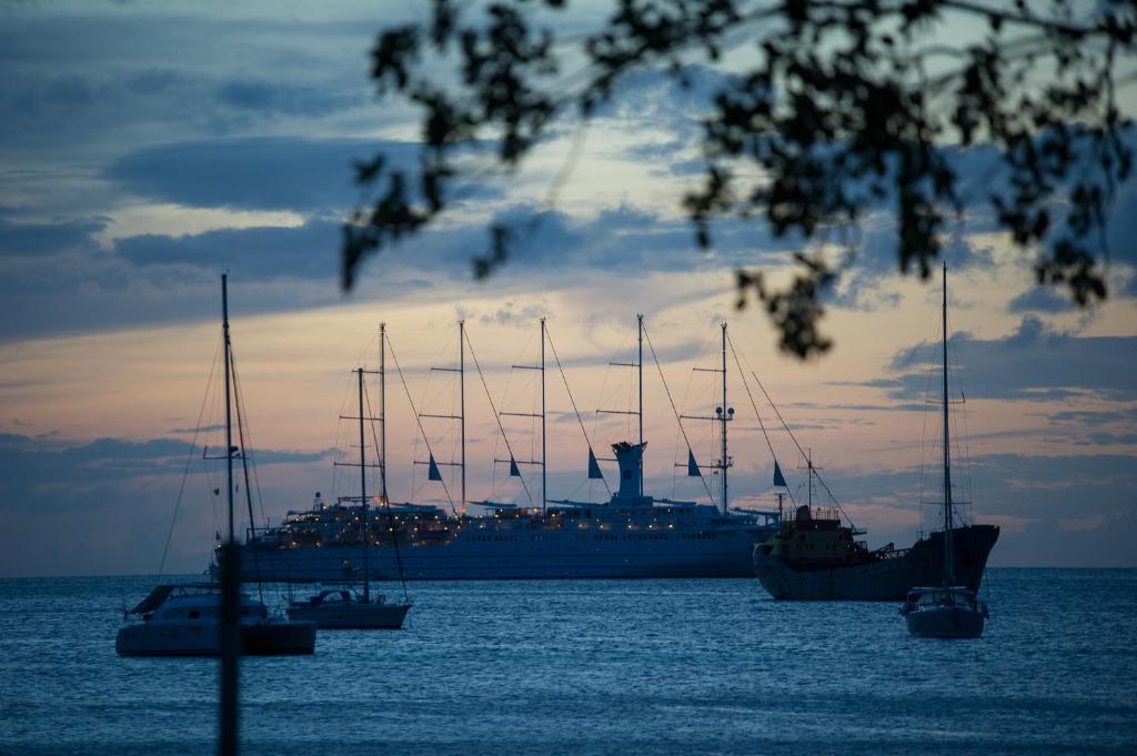 a large cruise ship in the water with boats at Bequia Plantation Hotel in Bequia
