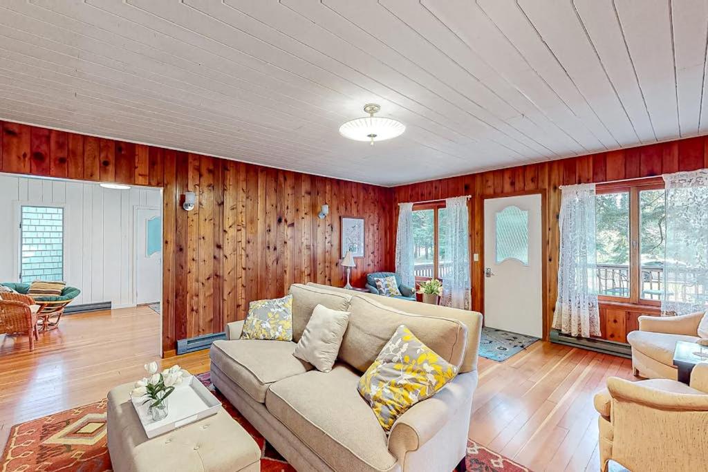 a living room with a couch and wooden walls at Wanderlust in Glen Arbor