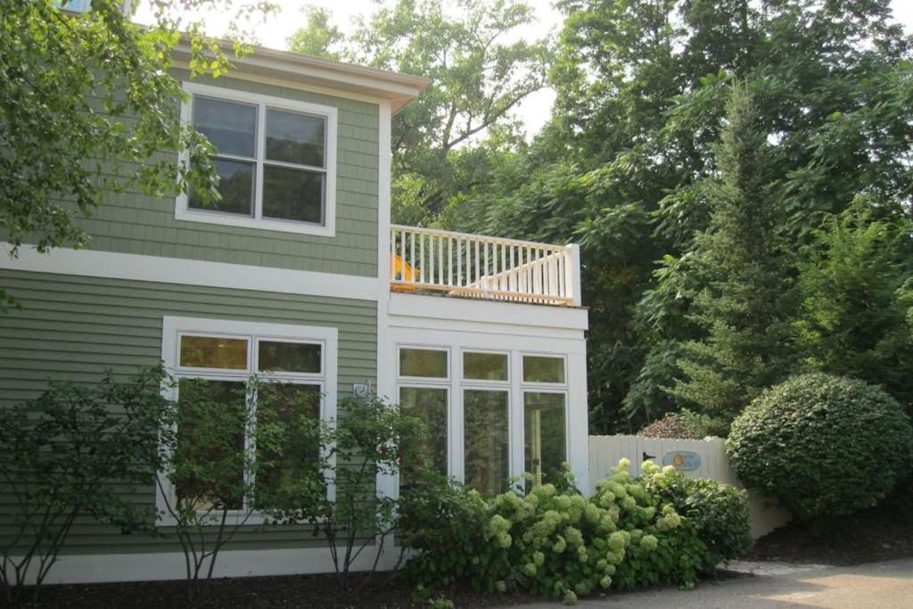 a green house with a balcony on top of it at Sunshine Villa in Union Pier