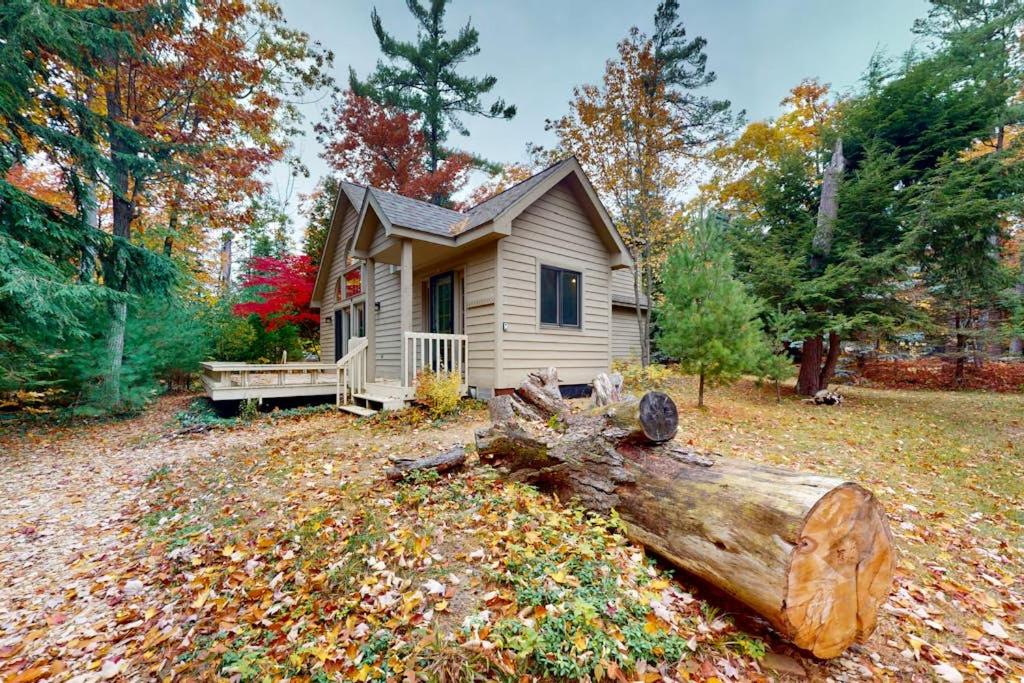 a small house with a log in front of it at Creeping Snails in Glen Arbor