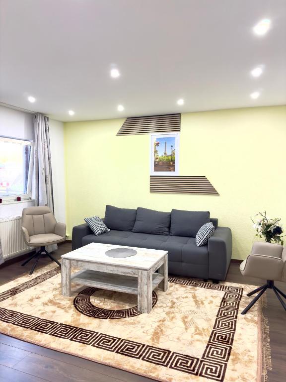 a living room with a blue couch and a table at MIO plus Apartments Sulzbach in Sulzbach