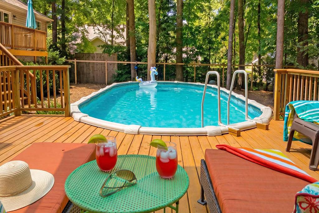 a swimming pool with two tables and drinks on a deck at Red Arrow Lodge in Sawyer