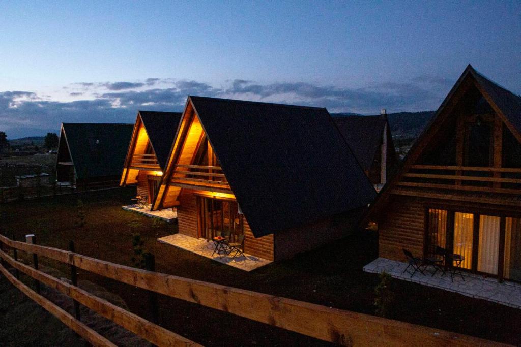 a house with a black roof and a wooden fence at Bugen Villa III in Žabljak