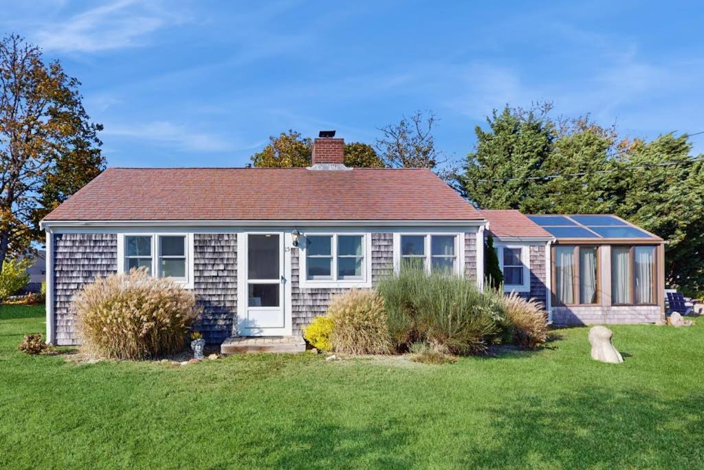 a small brick house with a grass yard at Coastal Hideaway in Eastham