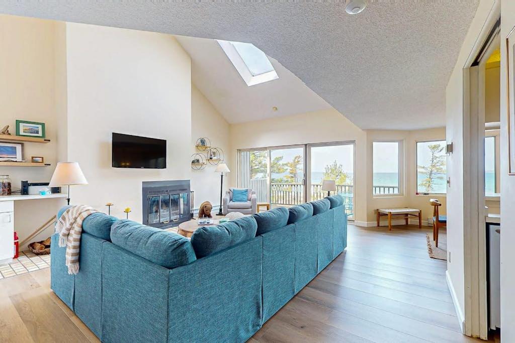 a blue couch in a living room with a fireplace at South Beach 25 in Glen Arbor