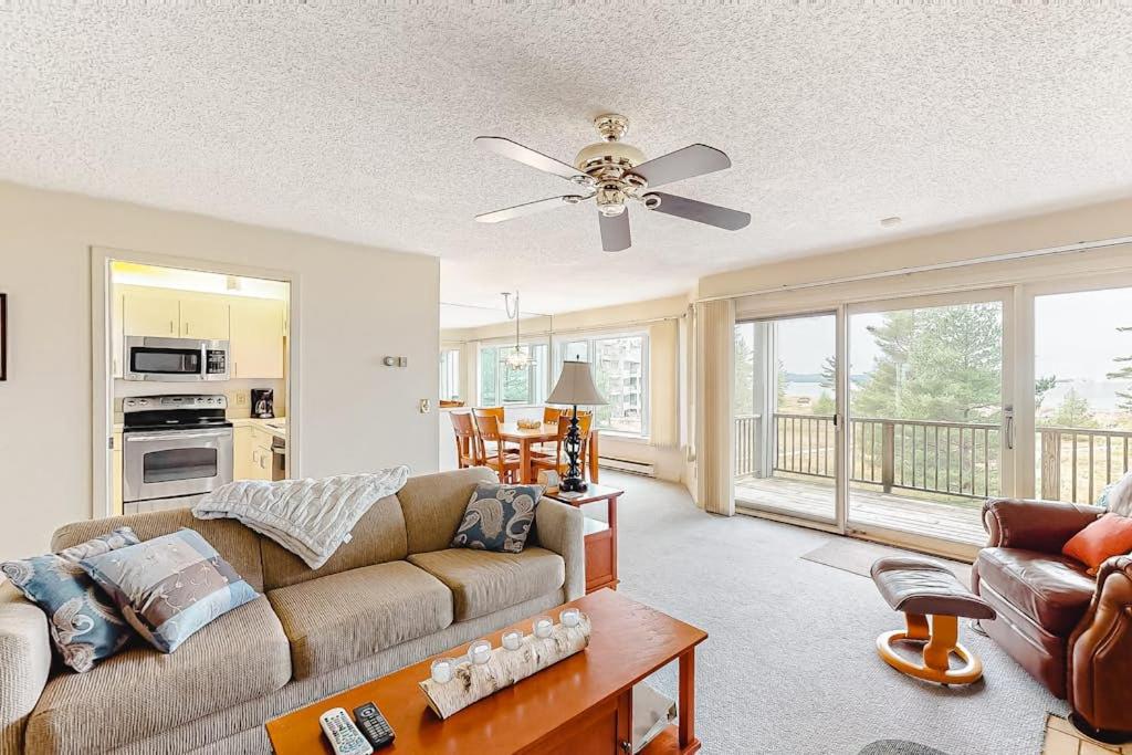 a living room with a couch and a ceiling fan at South Beach 53 in Glen Arbor