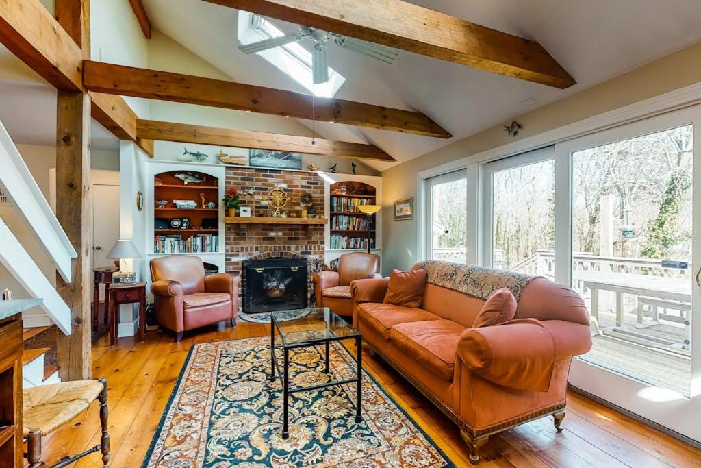 a living room with leather furniture and a fireplace at Paradise On Cape Cod in Orleans