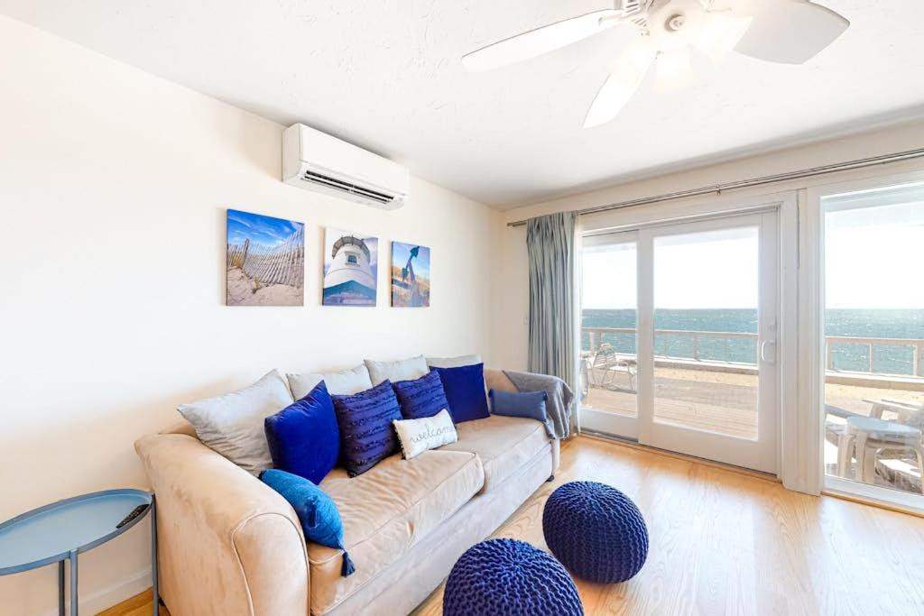 a living room with a couch with blue pillows at Nautical Haven at Seaside in North Truro