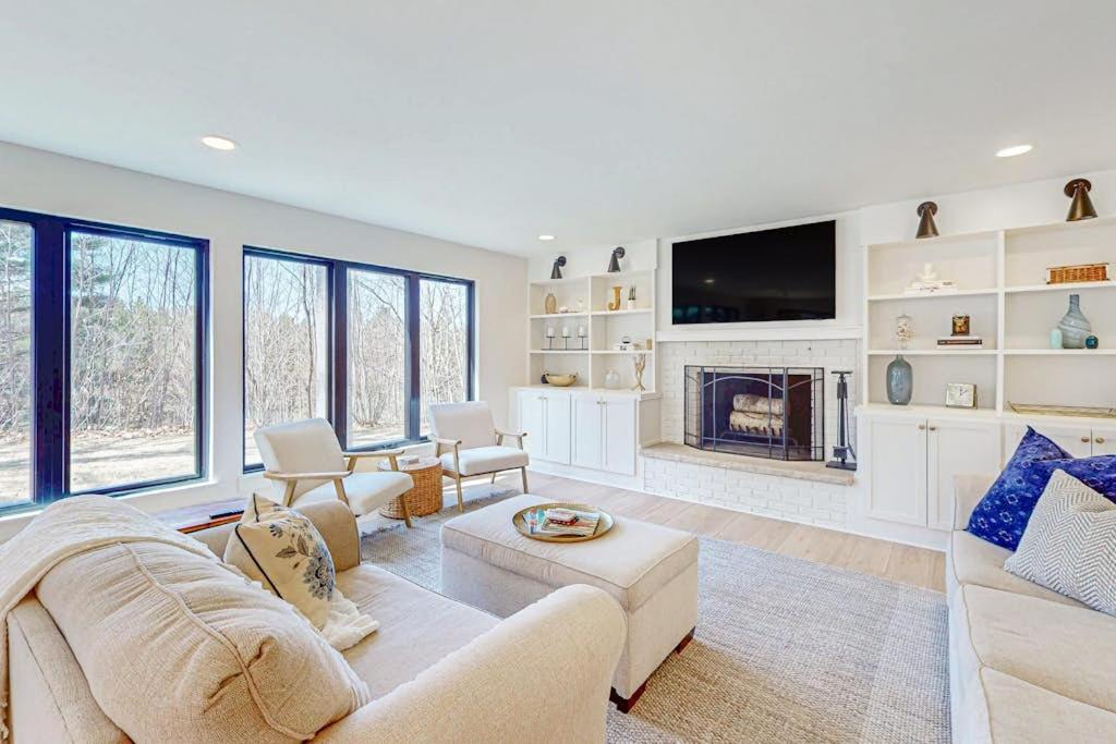a living room with white furniture and a fireplace at Torch Ridge Residence in Bellaire