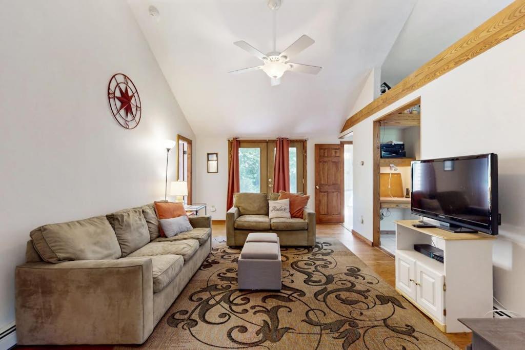 a living room with a couch and a flat screen tv at esCAPE in Eastham