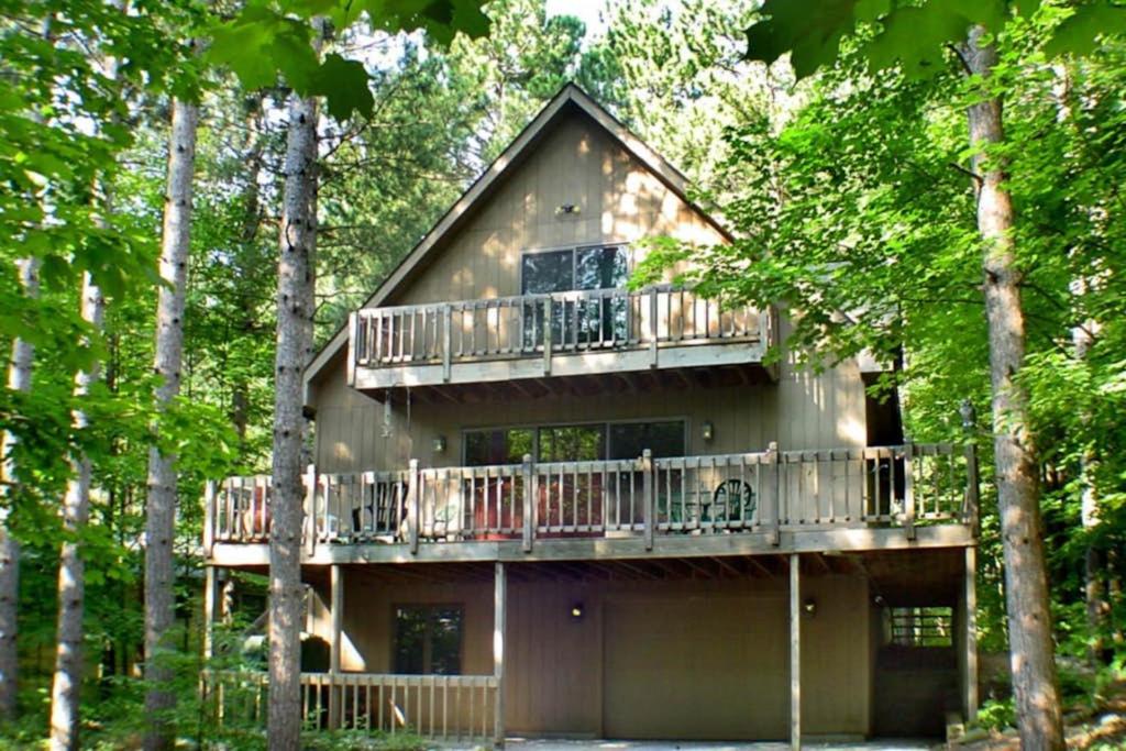 a large house with a deck in the woods at McKenzie's Lodge in Thompsonville