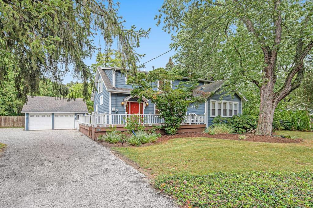 a blue house with a red door and a yard at Butterfly Pool House in Lakeside
