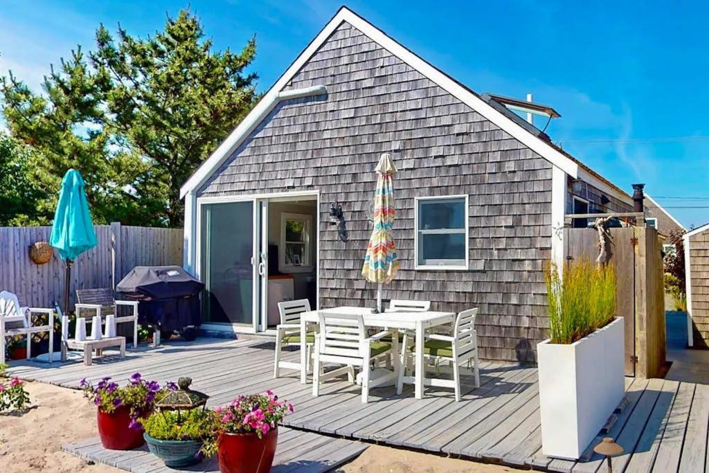 a patio with a table and chairs and an umbrella at Anchorage Escape in Truro