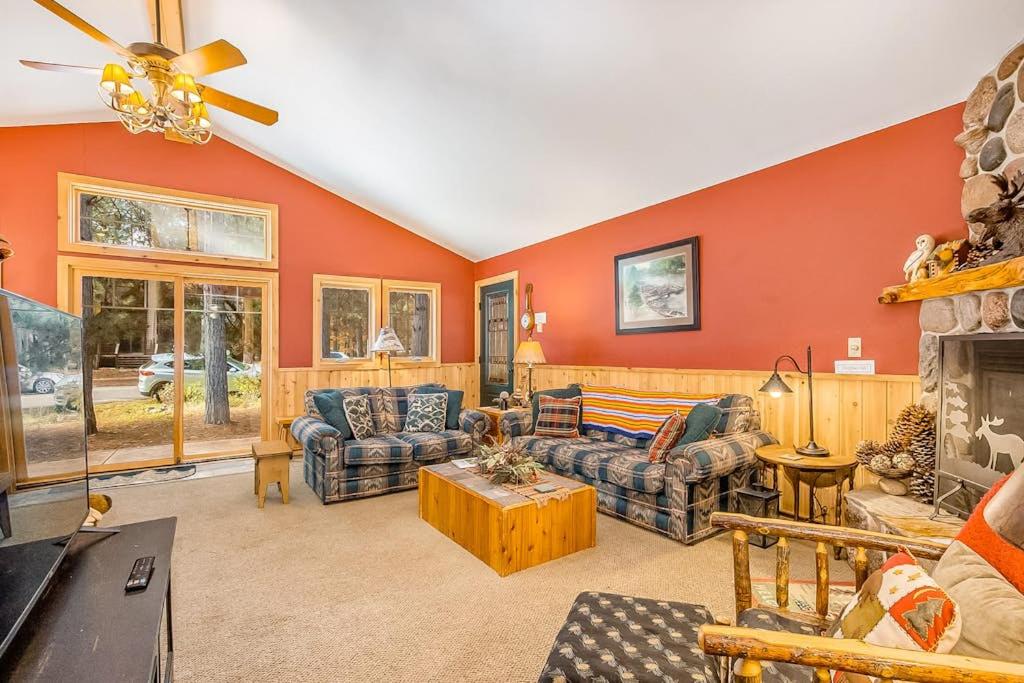 a living room with orange walls and couches and a fireplace at Whispering Pines in Thompsonville