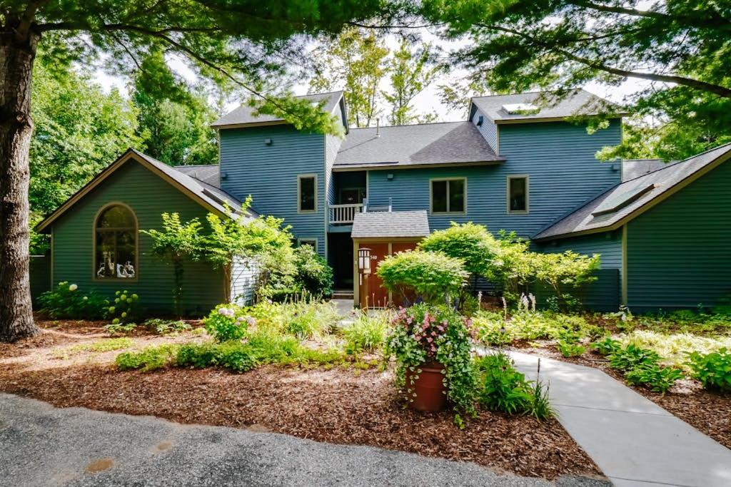 a home with a blue house and a yard at Wintergreen Condo, Unit 540 in Thompsonville