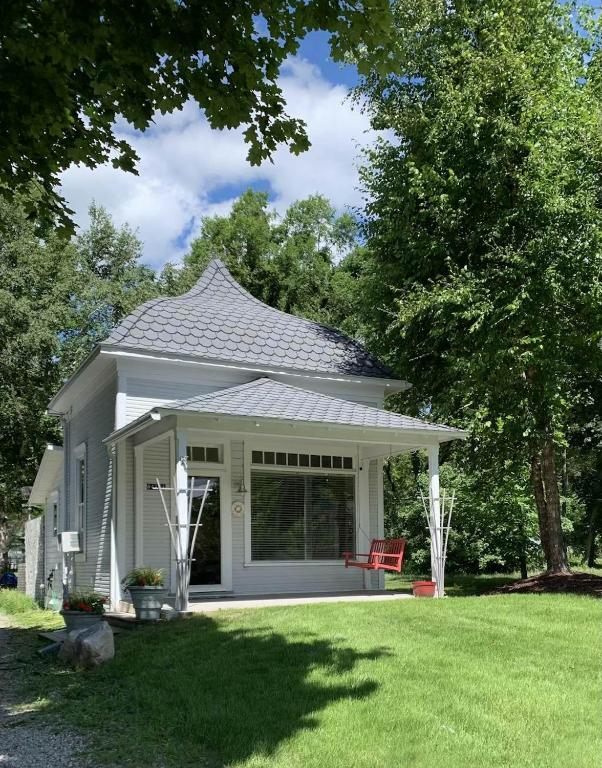 a white house with a red bench in a yard at Lake Daze in Boyne City