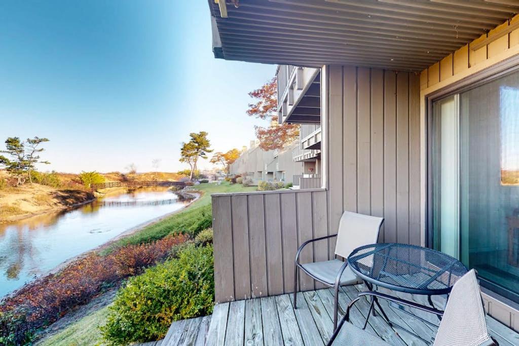 a balcony with a table and chairs and a river at Gentle Winds 9 10 in Glen Arbor