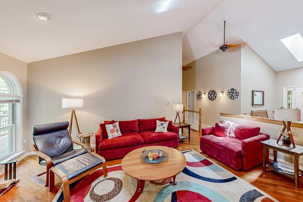 a living room with a red couch and a table at Betsie Woods in Thompsonville