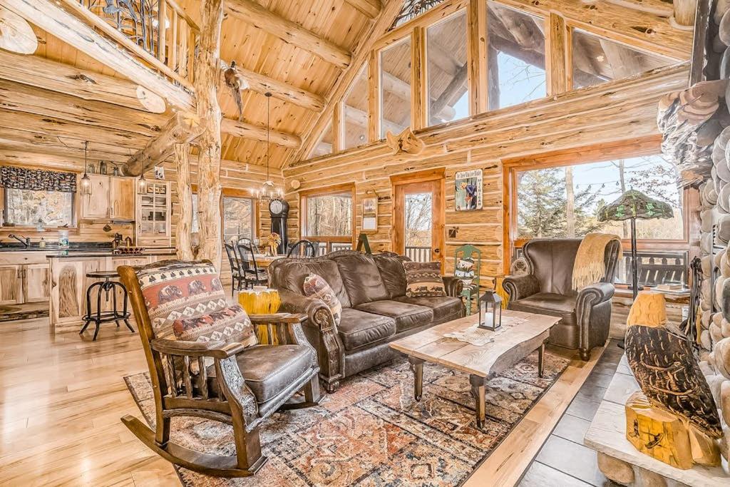 a living room with leather furniture and a wooden ceiling at Salmon Run in Thompsonville