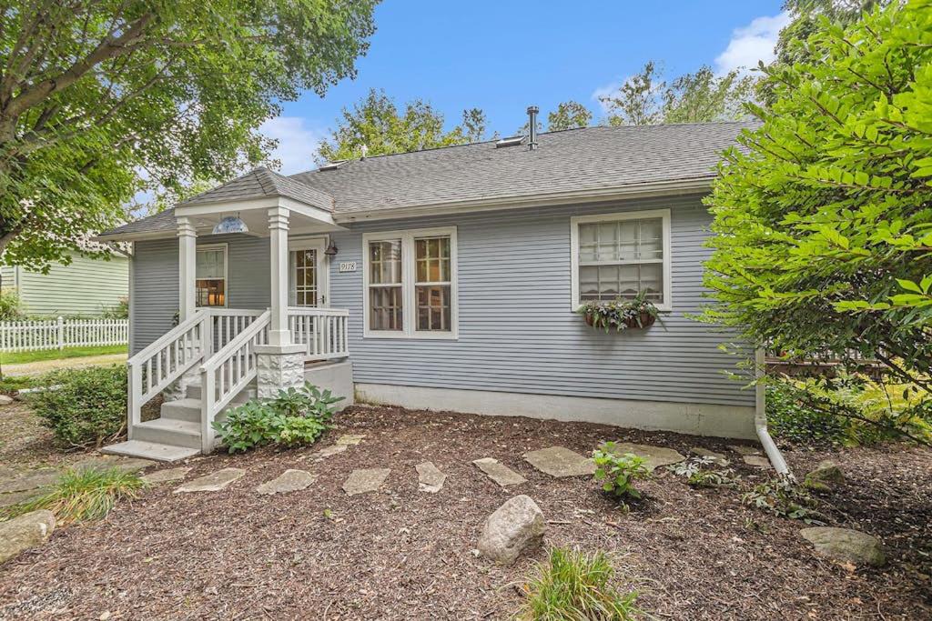 a small blue house with a porch and a yard at Painted Porch Cottage in Lakeside