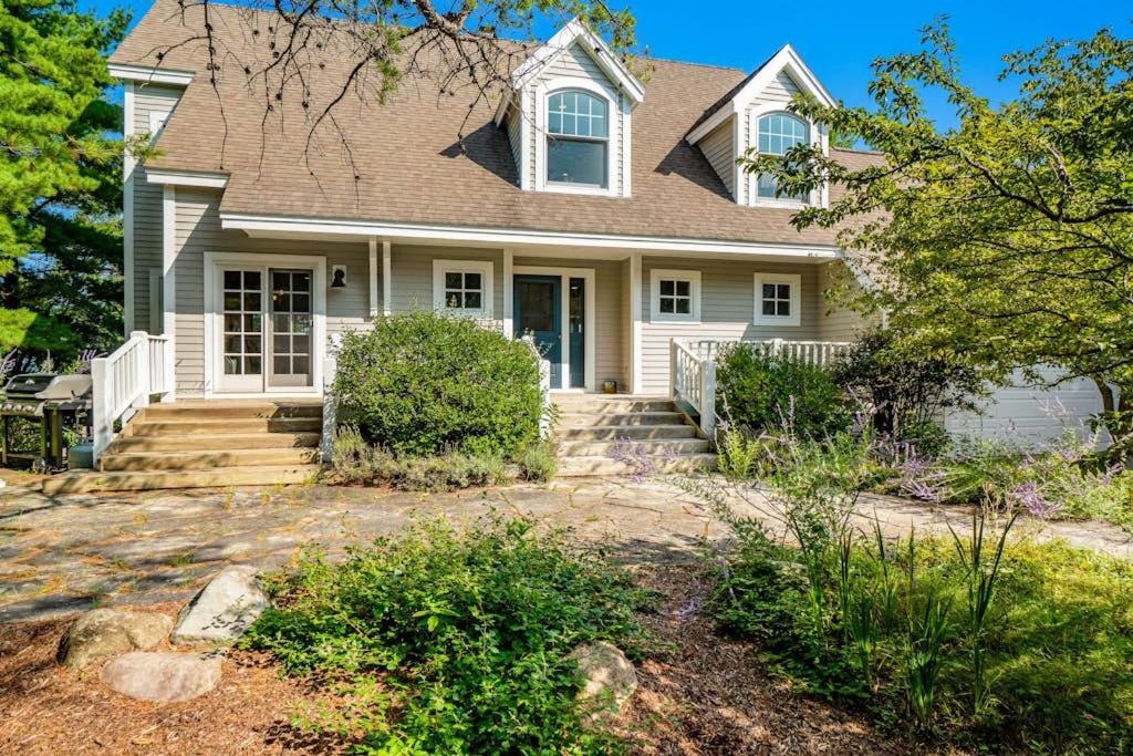 a white house with a porch and stairs at Blue Bear in Glen Arbor