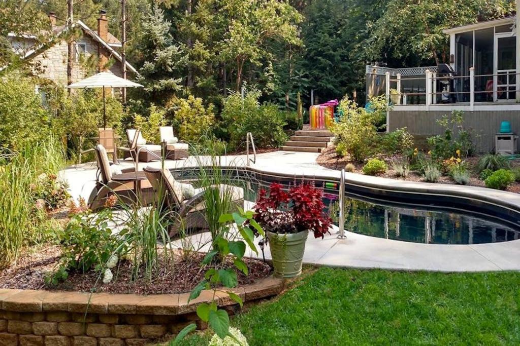 a garden with a pool and a table and chairs at Azure Forest Pool House in Union Pier