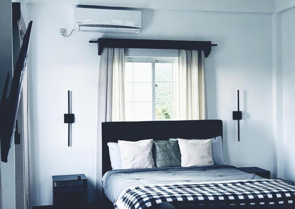 a bedroom with a bed with a window and a bed sidx sidx sidx at Green Valley Luxe Apartments in Kingstown