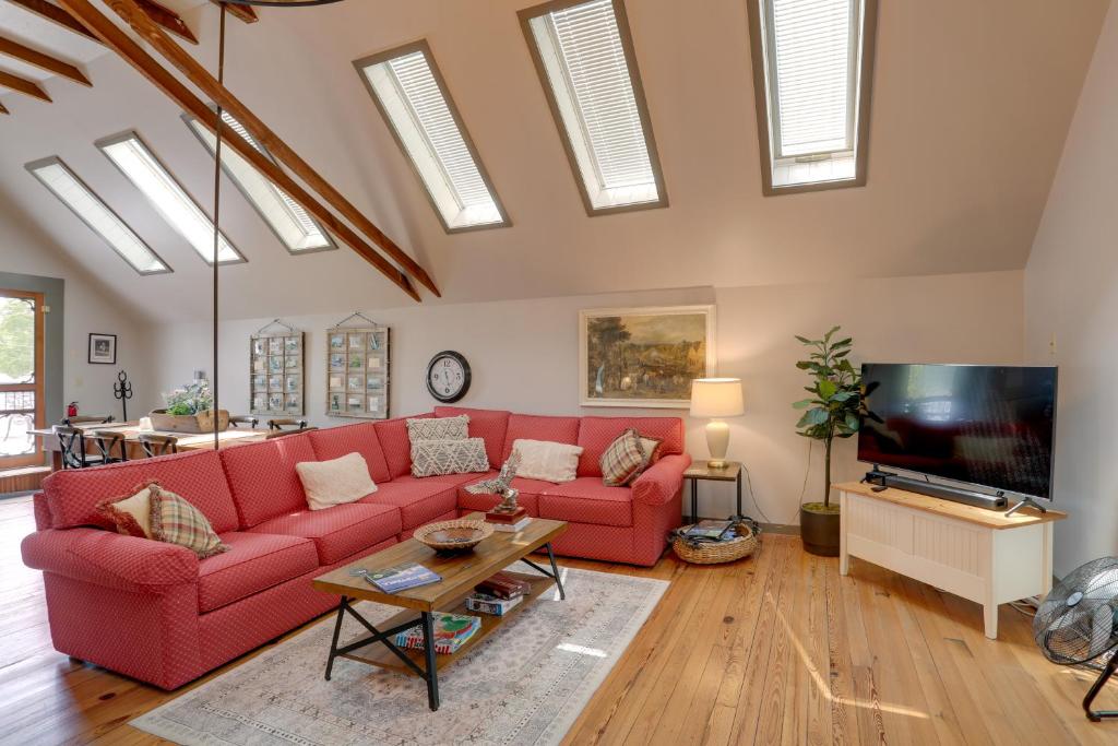 a living room with a red couch and a tv at Pet-Friendly Loft Vacation Rental w/ Fire Pit! in Bemus Point