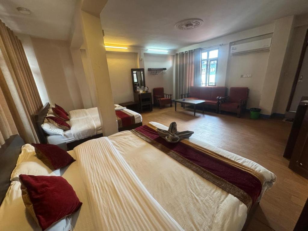 a hotel room with two beds and a living room at Hotel Silver Jubilee in Kathmandu