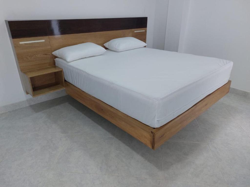 a bed with two pillows on it in a room at WARI RUNA HOSTAl 204 in Necoclí